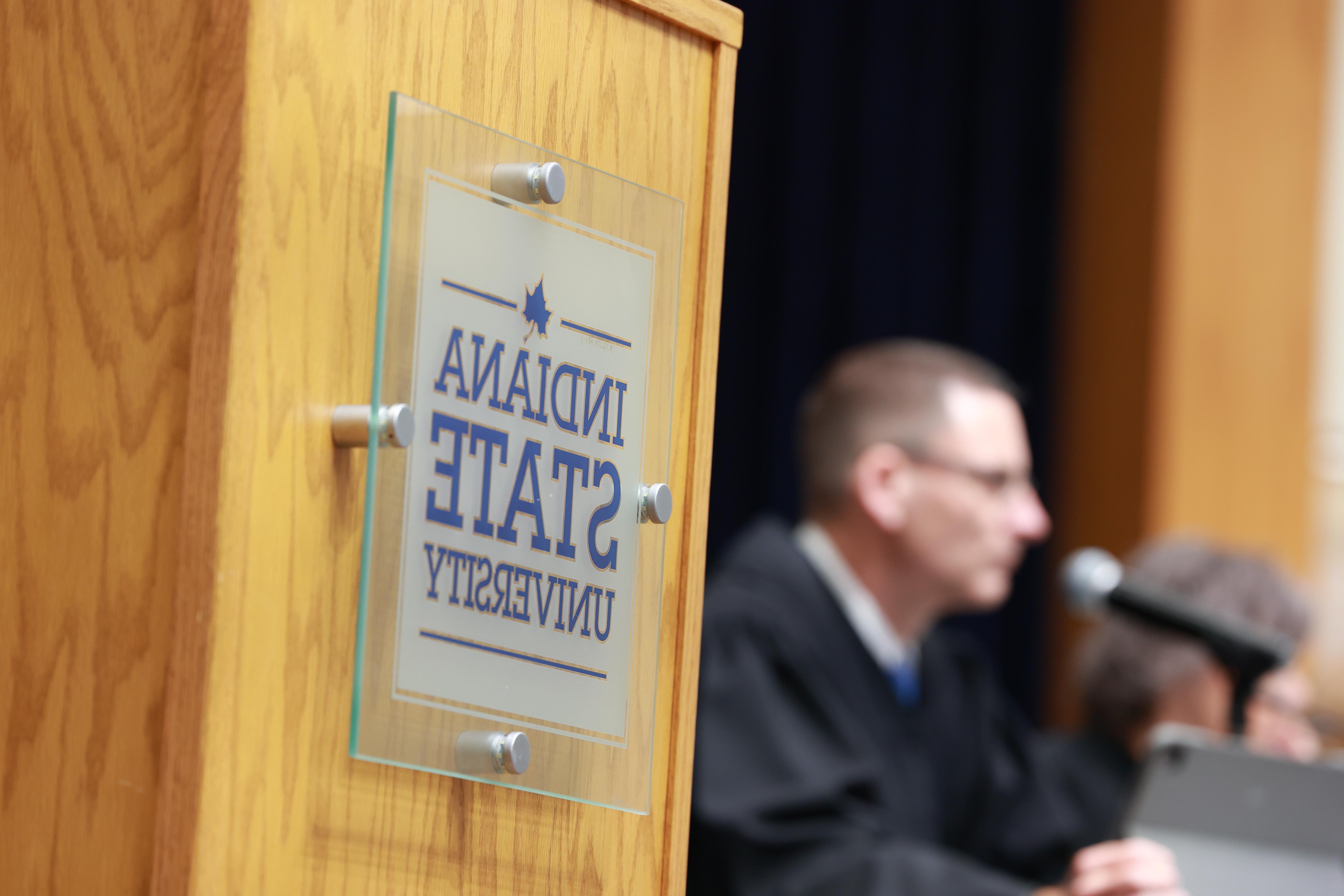 man in blurred background, speaking at ISU